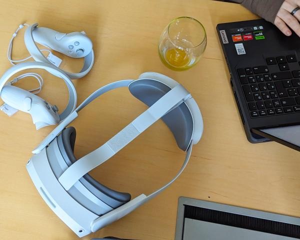 VR-Brillen und Kontroller auf Tisch neben Laptop