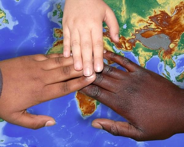 Drei Hände über Weltkarte