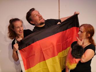 Drei Menschen mit einer Deutschlandfahne