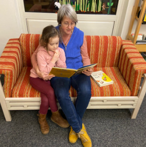 Eine Frau liest einem Kind ein Buch vor.