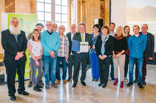 Fünfzehn Personen stehen für ein Foto zusammen im Rathaus