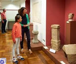 Frau und Mädchen stehen vor Ausstellungsstücken aus der Römerzeit