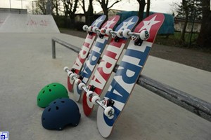 Skateboards und Helme lehnen an Pipe